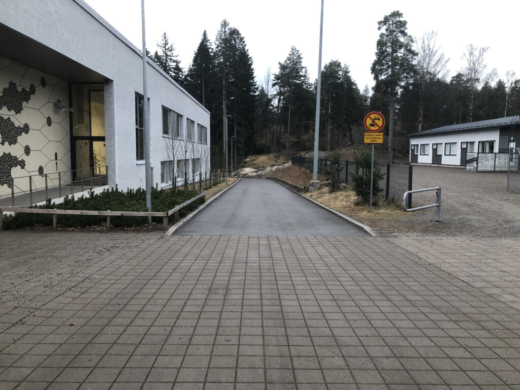 Picture of a downhill road leading to another parking lot near Myllypuro elementary school.